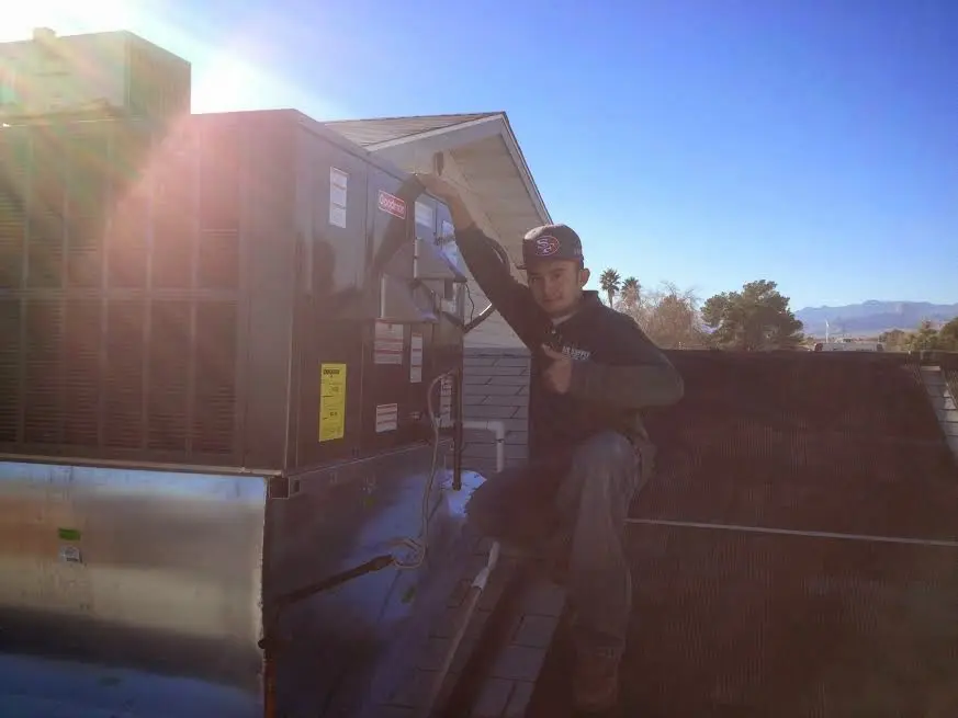 HVAC technician performing AC Tune-Up on a rooftop unit in North Fort Myers